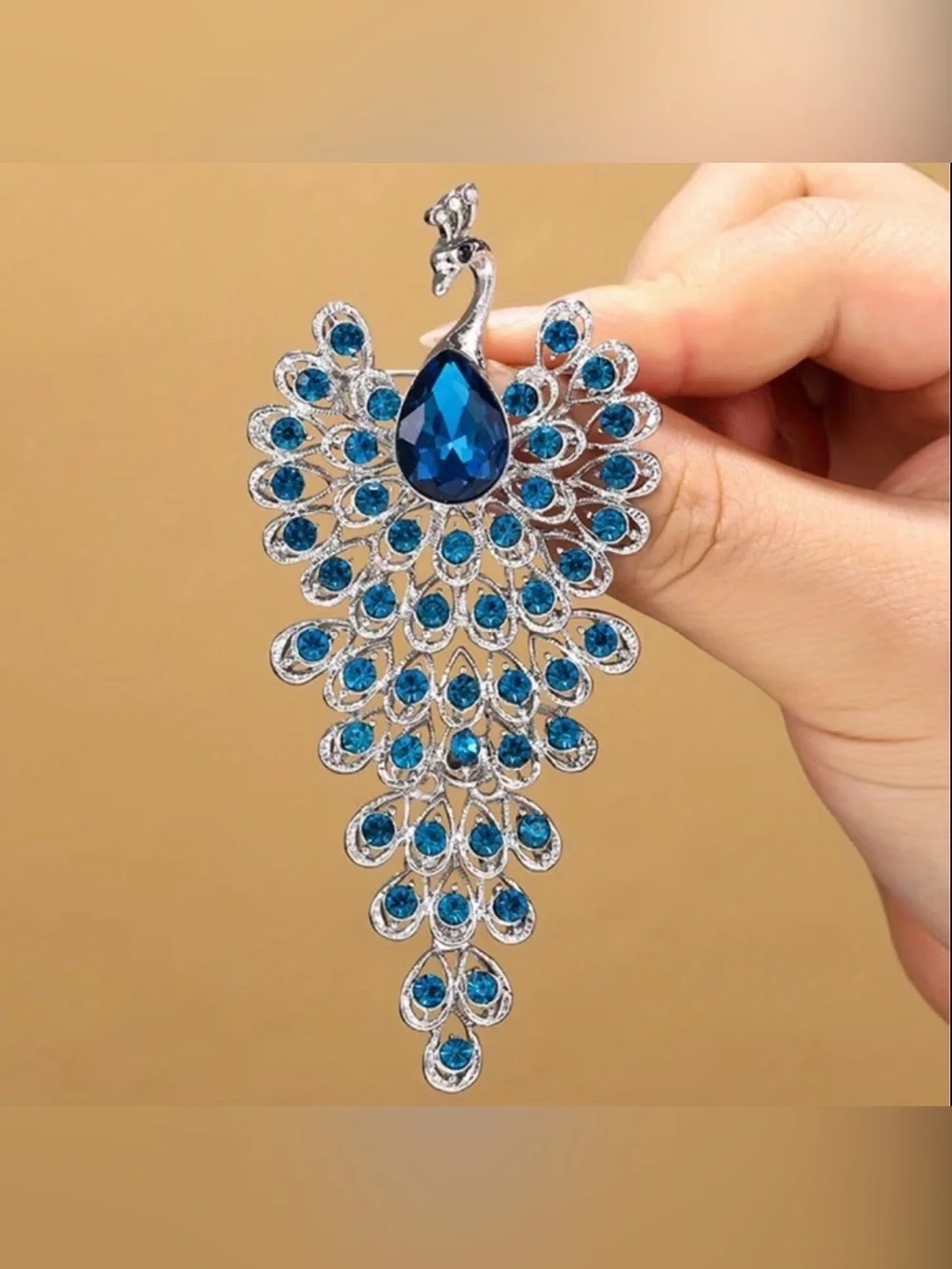 sparkling peacock-shaped statement brooch featuring blue crystals silver-tone
